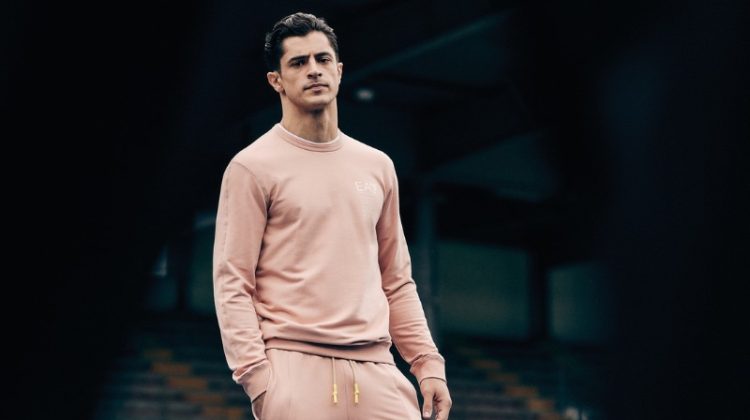 Cyrus Amini sports a matching sweatshirt and joggers by EA7.