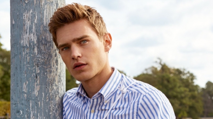 Bo Develius sports a striped oxford shirt with dark wash denim jeans by GANT.